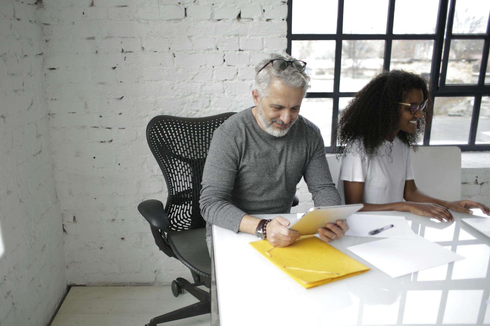 Business professionals collaborating over documents and laptop in a modern office.